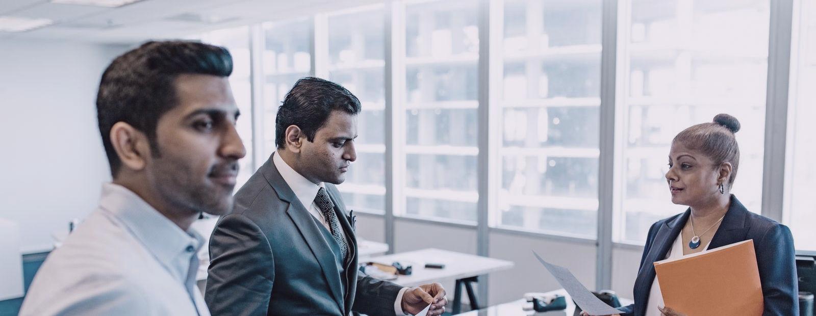 Colleagues reviewing papers together in an Indian office